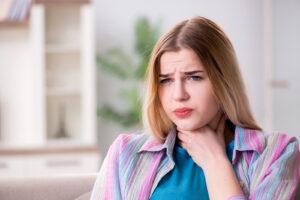 Young woman suffering from sore throat due to LPR