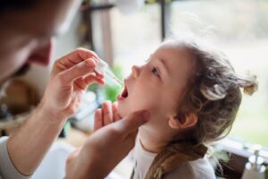 father-giving-allergy-drops-to-his-child